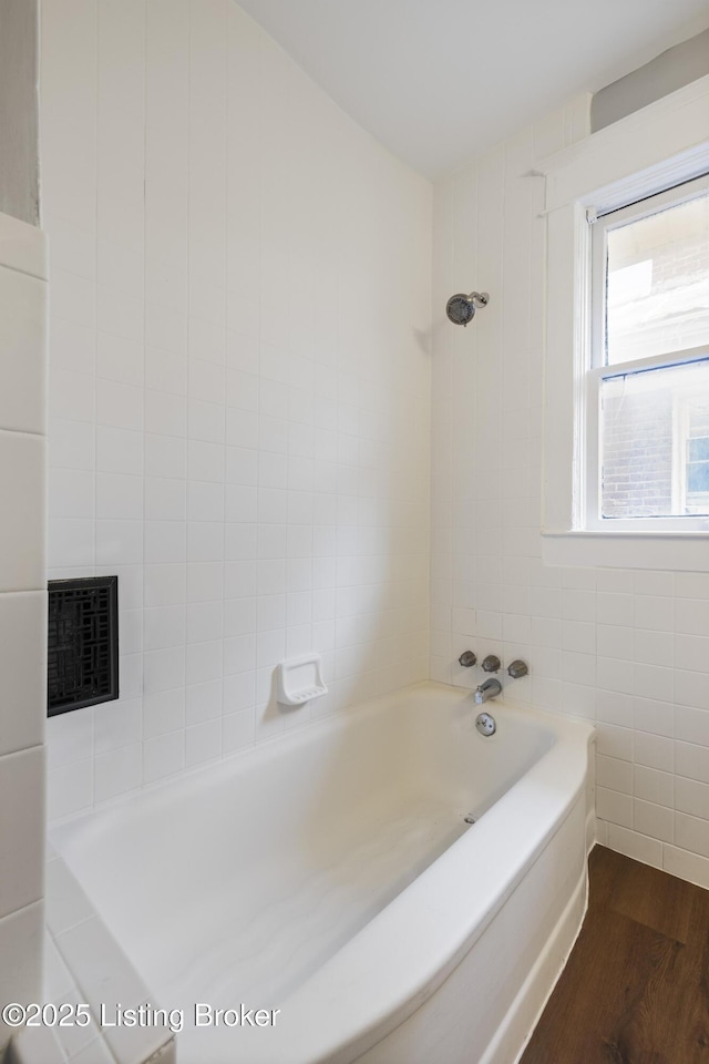 full bath featuring wood finished floors, visible vents, and tile walls