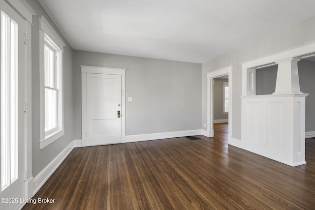 unfurnished room with dark wood-style floors and baseboards