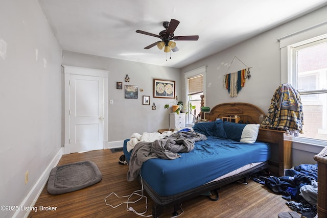 bedroom with wood finished floors, a ceiling fan, and baseboards