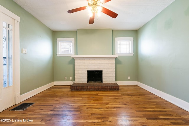 628 Harrison Ave, Louisville, KY 40217 - unfurnished living room with hardwood / wood-style floors, ceiling fan, a brick fireplace, and baseboards