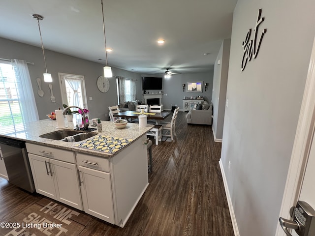 12023 Cascade Falls Trl, Louisville, KY 40229 - kitchen featuring dishwasher, open floor plan, white cabinetry, an island with sink, and a fireplace