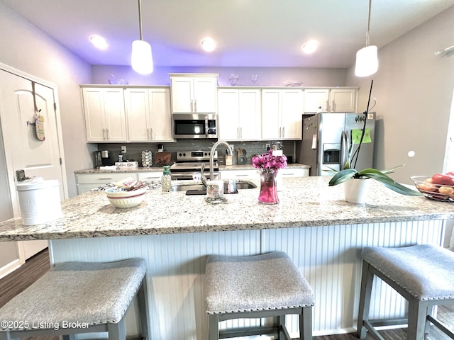 12023 Cascade Falls Trl, Louisville, KY 40229 - kitchen with stainless steel appliances, a breakfast bar area, white cabinets, and backsplash
