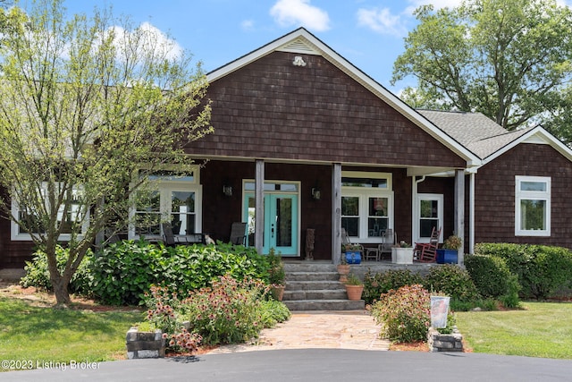 view of front of house featuring covered porch and a front yard