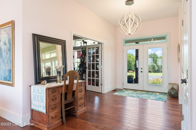 entrance foyer with french doors, a chandelier, and dark wood-type flooring