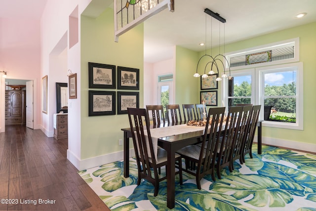 dining area featuring dark hardwood / wood-style flooring, a notable chandelier, and plenty of natural light