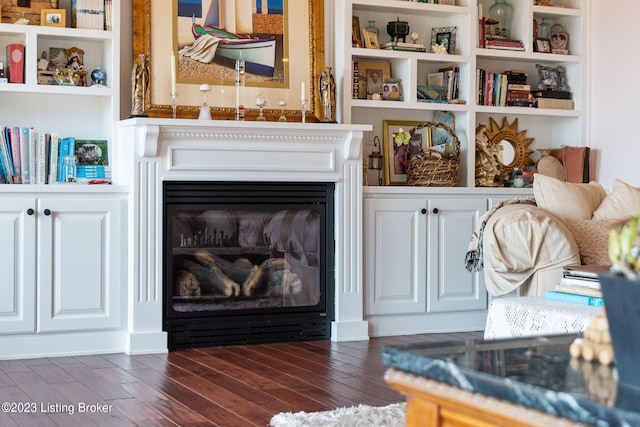 living room with dark hardwood / wood-style flooring and built in features