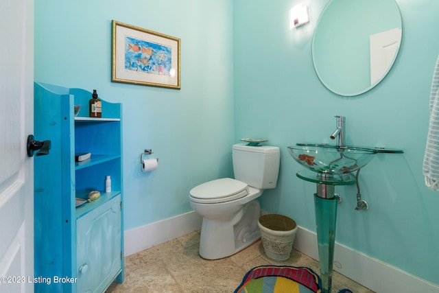 bathroom featuring tile flooring and toilet