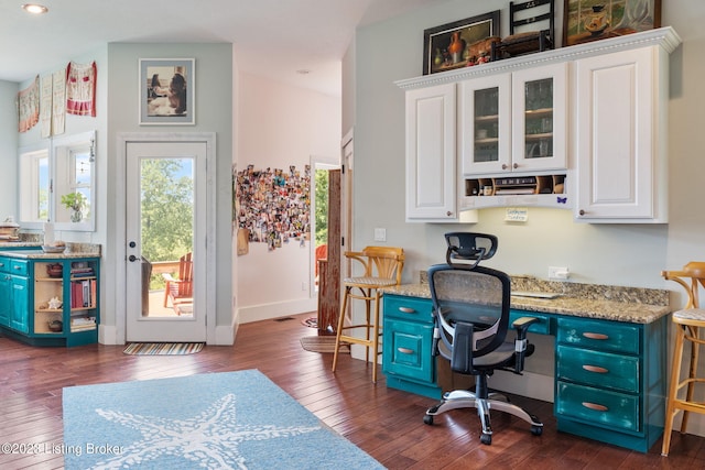 office space featuring dark hardwood / wood-style flooring and built in desk