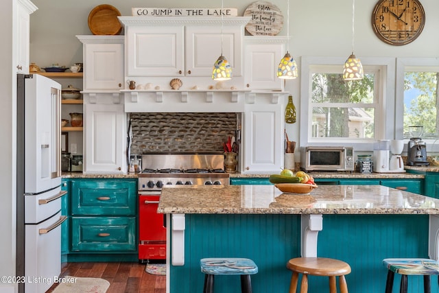 kitchen featuring stainless steel appliances, white cabinets, and a wealth of natural light