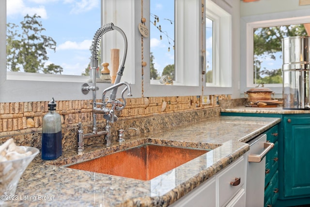 interior space with white cabinets, light stone countertops, and dishwasher