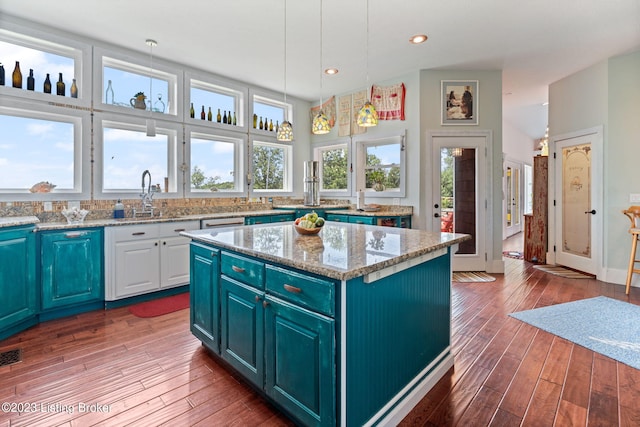 kitchen with decorative light fixtures, a kitchen island, dark hardwood / wood-style floors, and blue cabinets