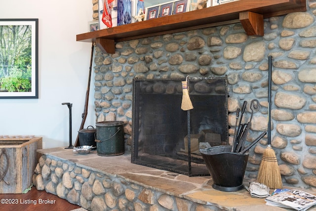 interior details with a stone fireplace and dark hardwood / wood-style floors