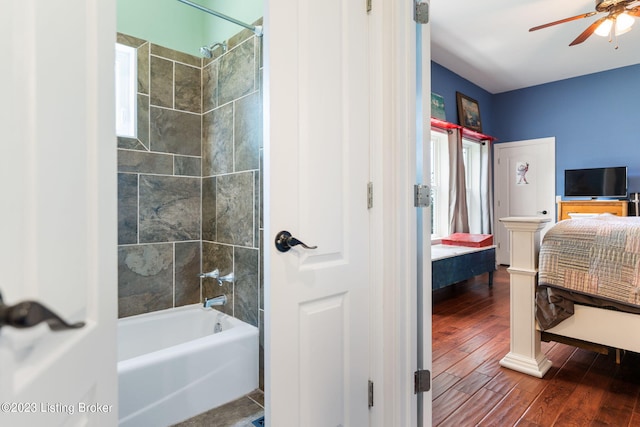 bathroom featuring ceiling fan, tiled shower / bath, and wood-type flooring