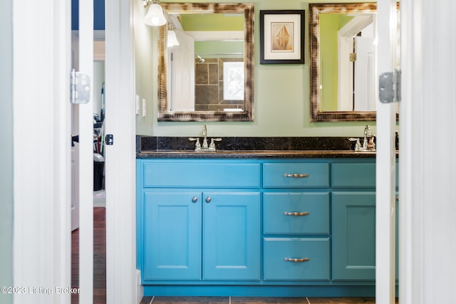 bathroom featuring oversized vanity, wood-type flooring, and dual sinks