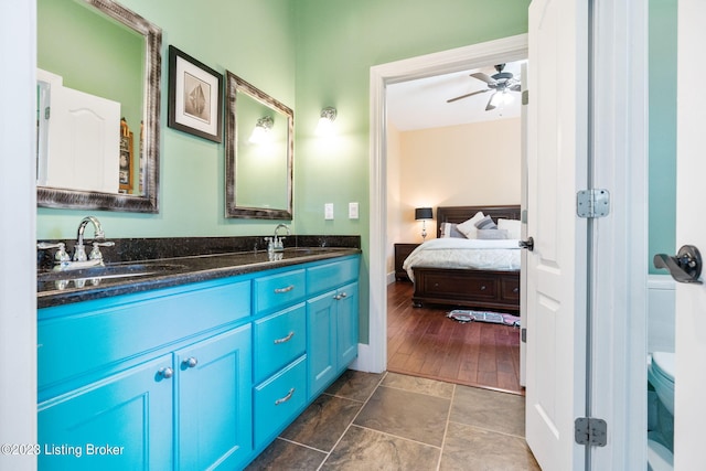 bathroom with ceiling fan, tile floors, dual sinks, toilet, and large vanity