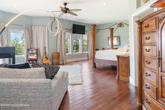 bedroom featuring ceiling fan, multiple windows, and dark hardwood / wood-style flooring