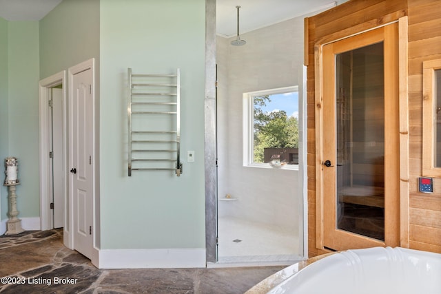 bathroom with radiator, a bathing tub, and tile floors