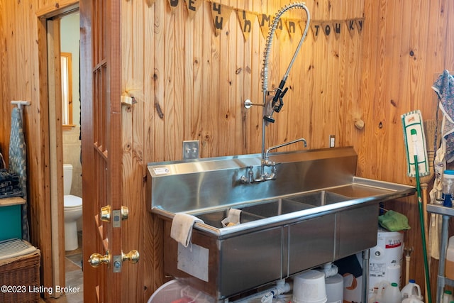 bathroom with wooden walls and toilet