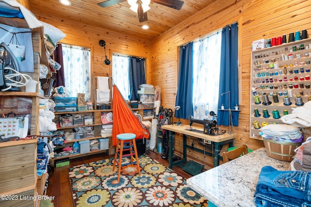 bedroom featuring dark hardwood / wood-style flooring, wood walls, and multiple windows