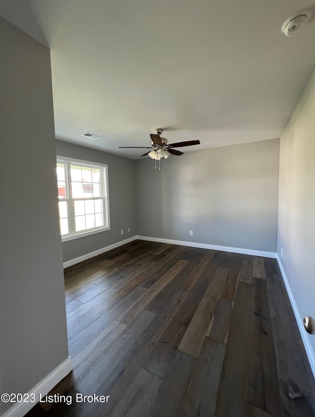 empty room with ceiling fan and dark wood-type flooring