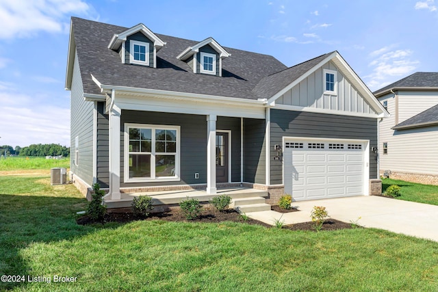 view of front of house featuring a porch, board and batten siding, a front yard, a garage, and driveway