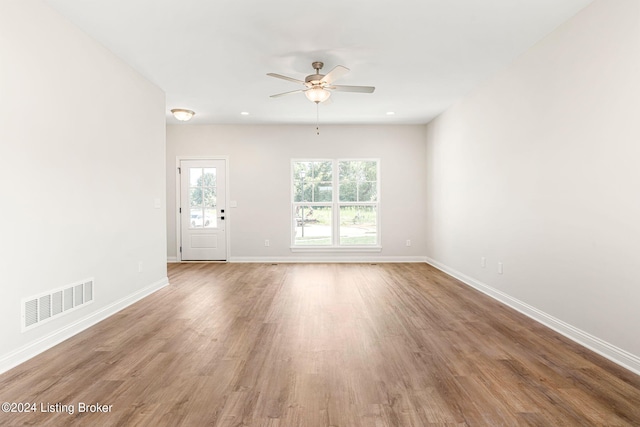 unfurnished living room with recessed lighting, wood finished floors, a ceiling fan, visible vents, and baseboards