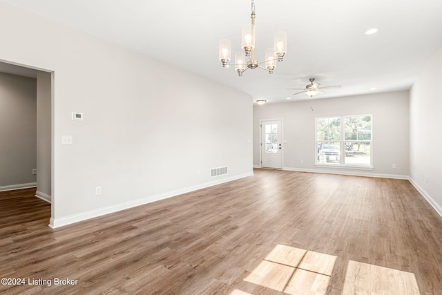 unfurnished living room with recessed lighting, visible vents, wood finished floors, baseboards, and ceiling fan with notable chandelier