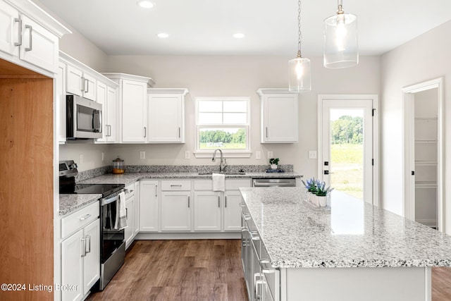 kitchen with dark wood-style floors, appliances with stainless steel finishes, white cabinets, and a sink