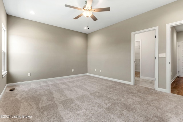 unfurnished room with baseboards, carpet, visible vents, and a ceiling fan