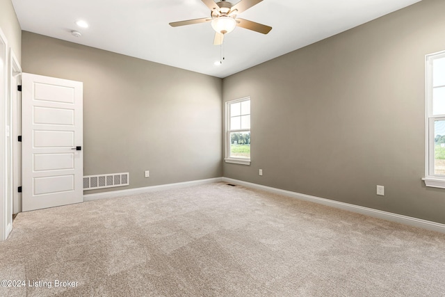 spare room with baseboards, visible vents, ceiling fan, and carpet flooring