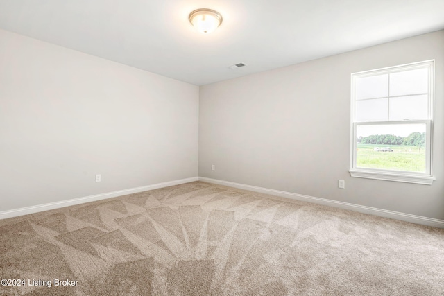 spare room featuring carpet flooring, visible vents, and baseboards