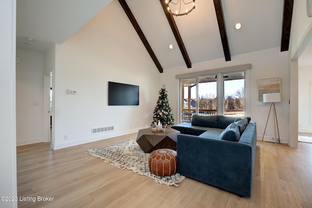 living room with a notable chandelier, beam ceiling, light hardwood / wood-style flooring, and high vaulted ceiling