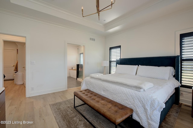 bedroom featuring a notable chandelier, ornamental molding, a raised ceiling, and light wood-type flooring