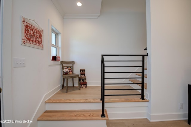 staircase featuring hardwood / wood-style flooring and crown molding