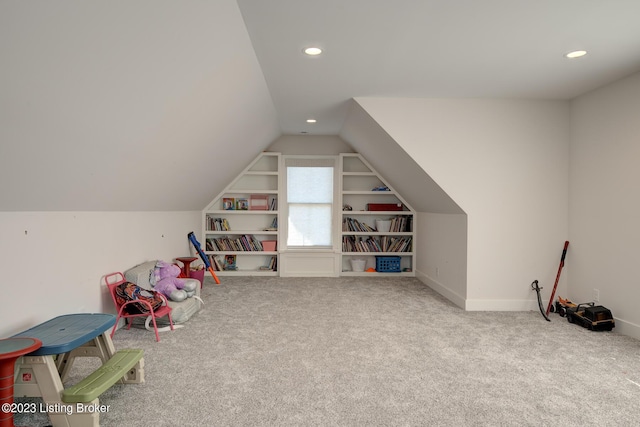 recreation room featuring vaulted ceiling, built in shelves, and carpet floors