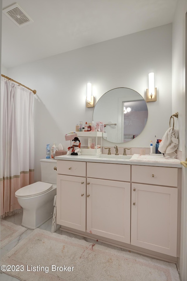 bathroom with vanity, curtained shower, and toilet