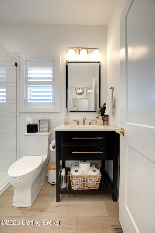 bathroom with walk in shower, vanity, toilet, and hardwood / wood-style floors