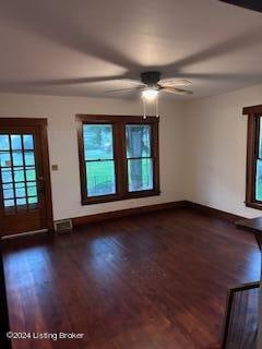 unfurnished living room with dark hardwood / wood-style floors and ceiling fan