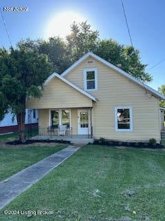 bungalow-style home with a front yard