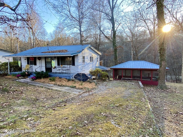 view of front facade with a sunroom and covered porch