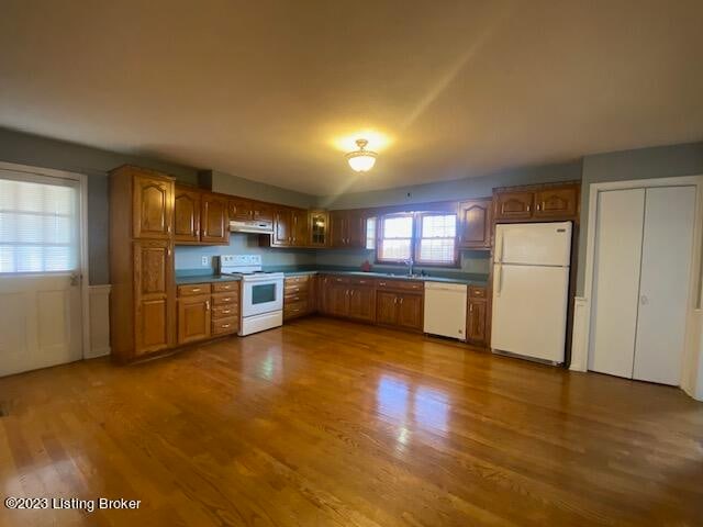 kitchen featuring white appliances, dark hardwood / wood-style floors, and sink