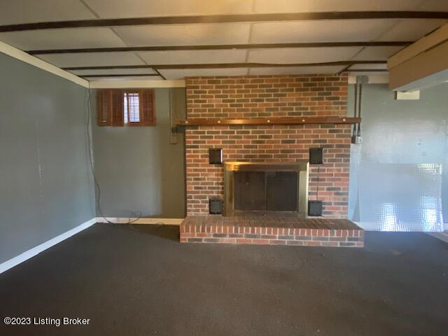 unfurnished living room with a fireplace and carpet