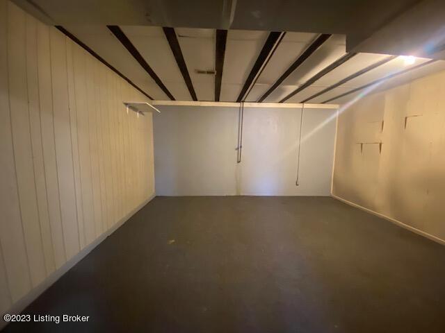 basement featuring wood walls