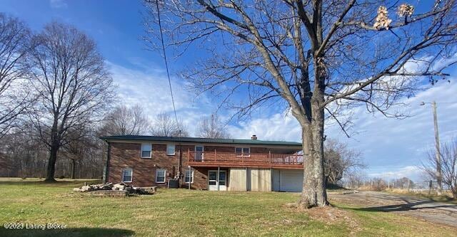 back of house featuring cooling unit and a lawn