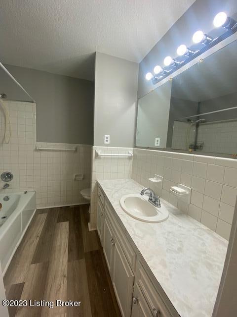 full bathroom featuring vanity, toilet, tile walls, and hardwood / wood-style flooring