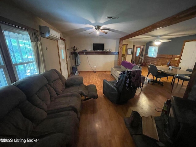 living room featuring ceiling fan, a wall mounted air conditioner, and light hardwood / wood-style floors