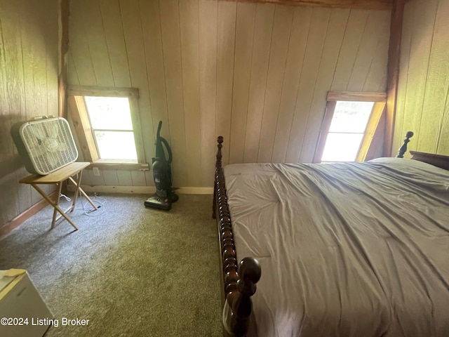 unfurnished bedroom with wood walls and carpet floors