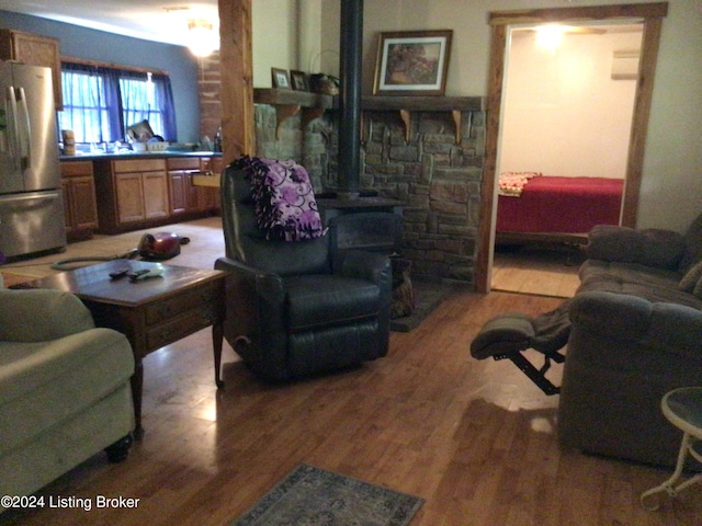 living room with hardwood / wood-style floors and a wood stove