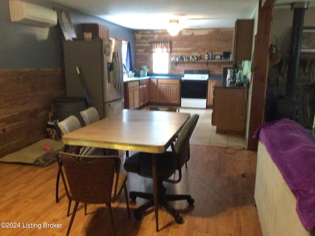 dining space featuring a wall mounted air conditioner and light hardwood / wood-style floors