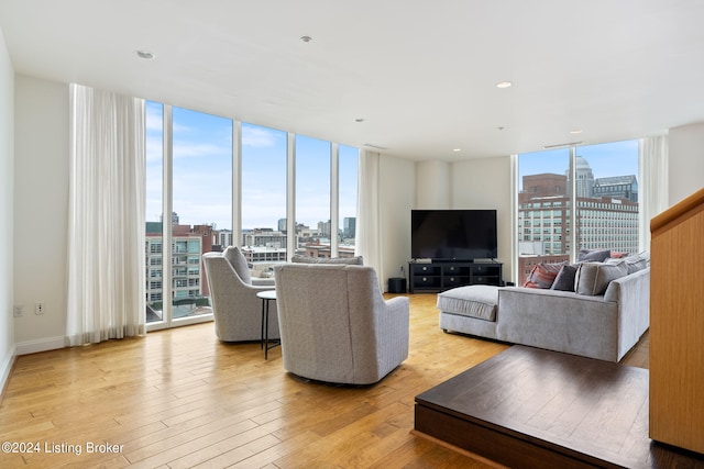 living room featuring a wall of windows and light hardwood / wood-style flooring